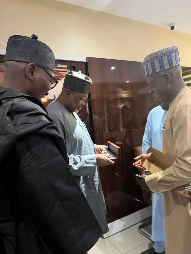 Dr. Alabi alongside senior delegates presenting an official wooden award/presentation box to the Minister of Agriculture, Senator Abubakar Kyari.